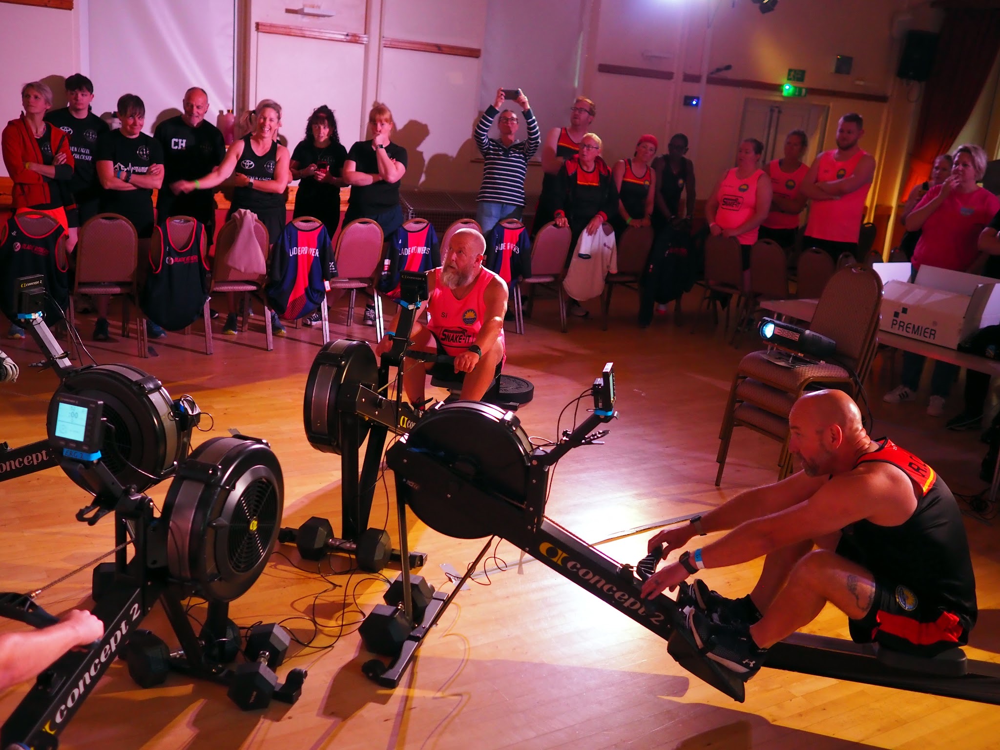Rowers racing head to head in front of a crowd at the Indoor Rowing Team Championships
