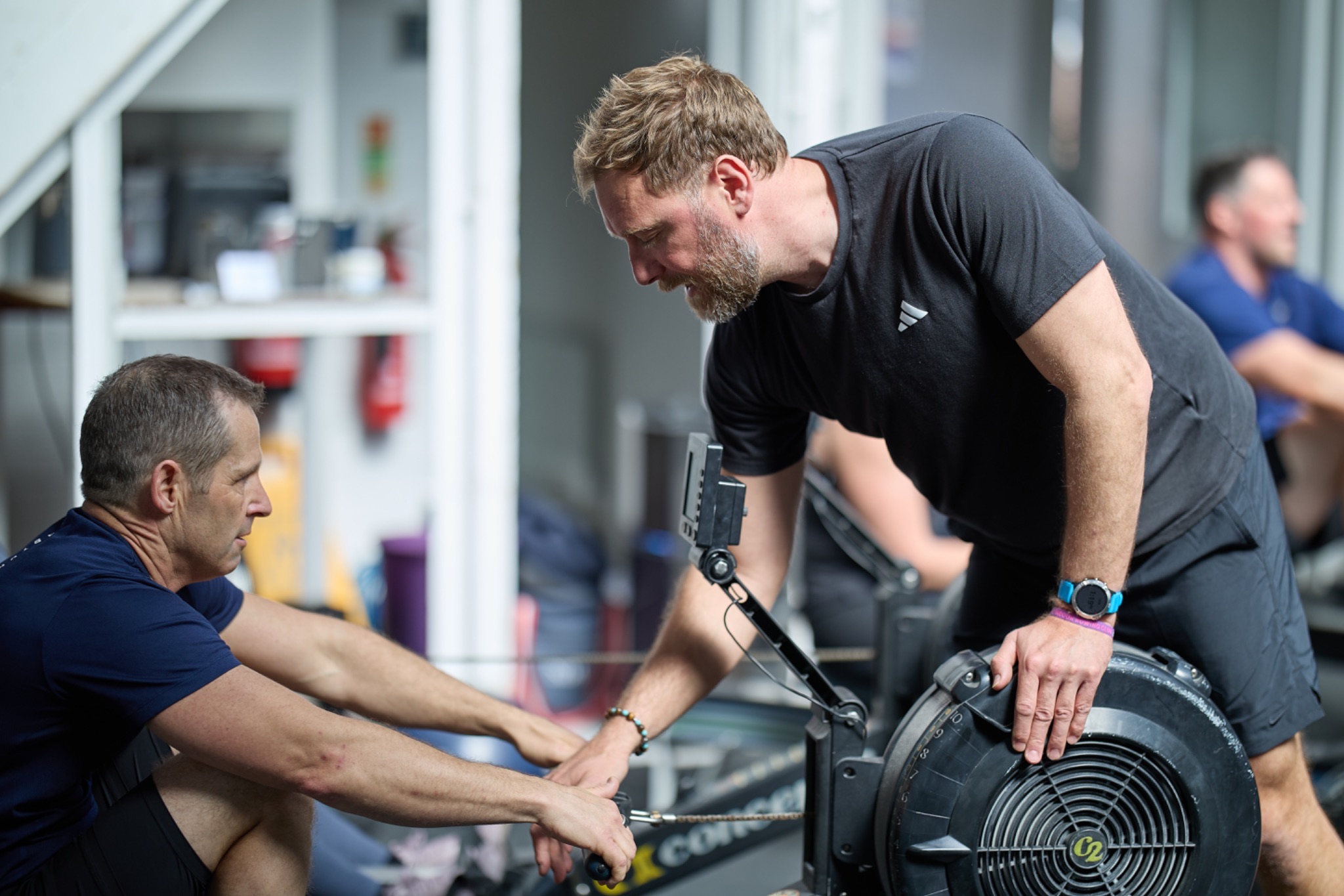 Rob adjusting a rower's hand position on the handle
