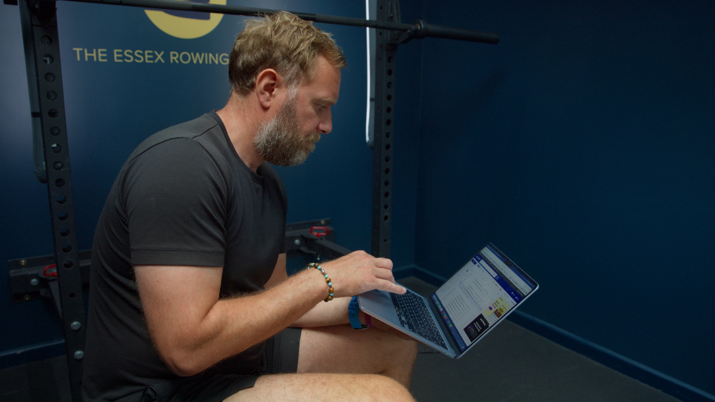 Rob reviewing rowing footage on a laptop